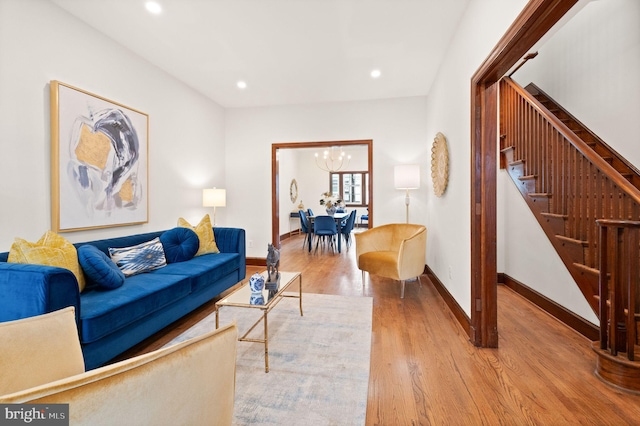 living area featuring baseboards, stairway, recessed lighting, an inviting chandelier, and wood finished floors