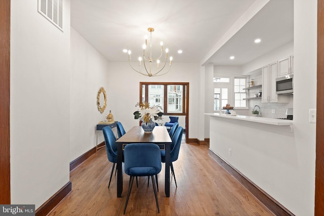 dining room featuring visible vents, baseboards, recessed lighting, an inviting chandelier, and light wood-style floors