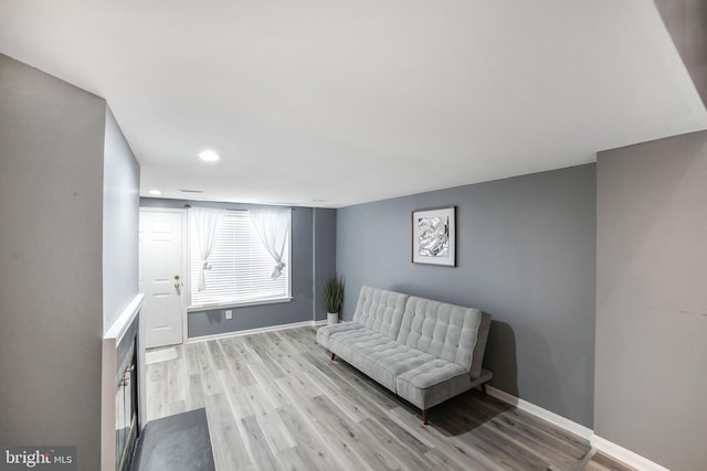 sitting room with baseboards and light wood-style flooring