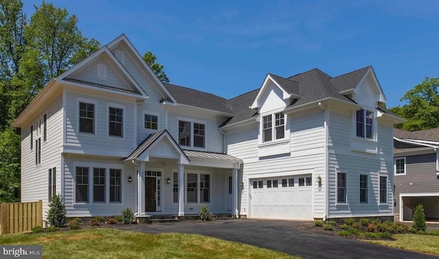 view of front of home with fence, a garage, and driveway