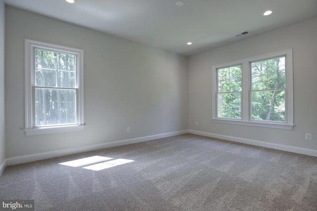 carpeted empty room with visible vents, recessed lighting, and baseboards