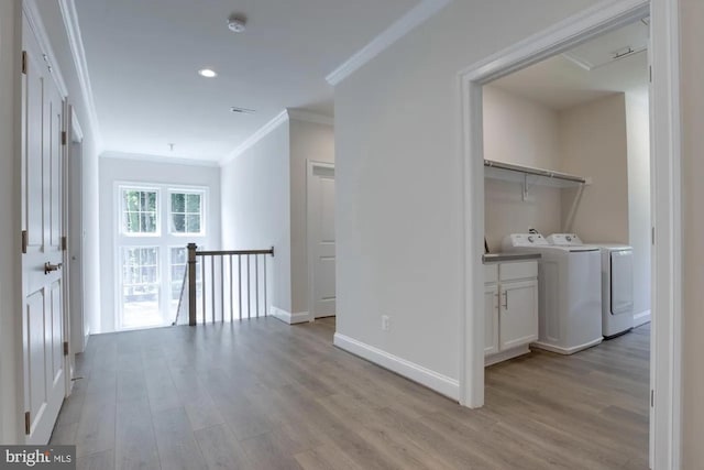 hall with an upstairs landing, light wood-style flooring, crown molding, and separate washer and dryer