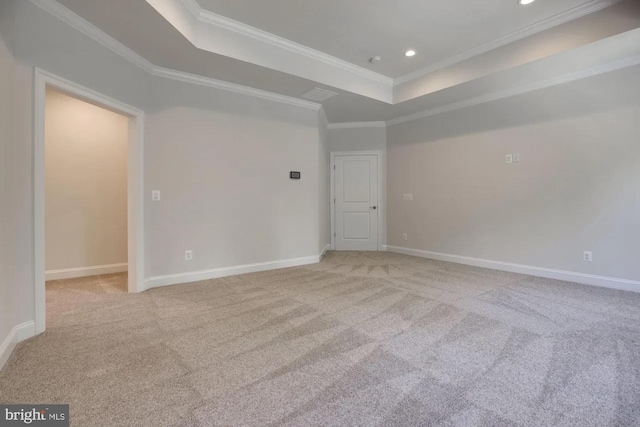 spare room featuring baseboards, a raised ceiling, carpet floors, and ornamental molding