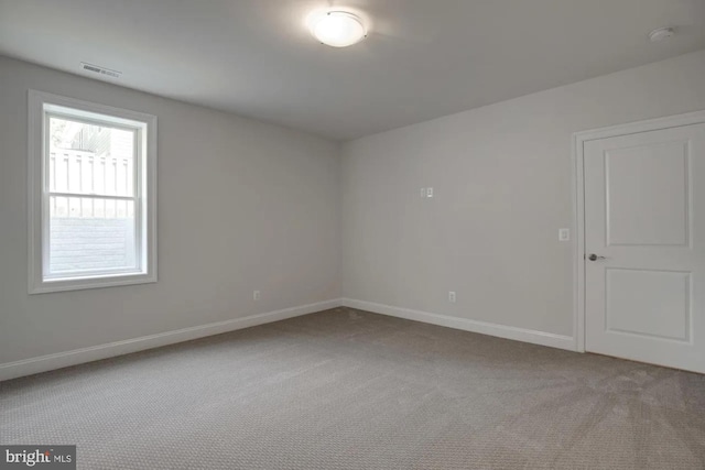 empty room featuring baseboards, visible vents, and carpet floors