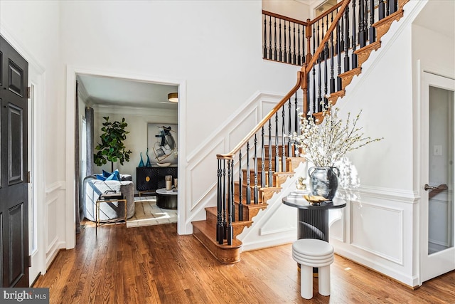 entryway with a decorative wall, stairway, and wood finished floors