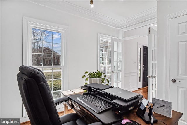 office area featuring a wainscoted wall, light wood finished floors, french doors, crown molding, and a decorative wall