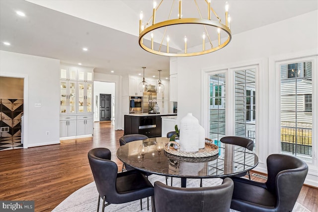 dining area featuring dark wood-style floors, a chandelier, recessed lighting, and baseboards