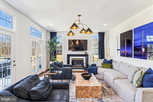 living area with recessed lighting, plenty of natural light, wood finished floors, and a fireplace