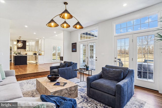 living area with recessed lighting, french doors, and wood finished floors