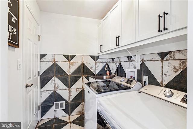 washroom with visible vents, washer and clothes dryer, a sink, cabinet space, and tile patterned flooring