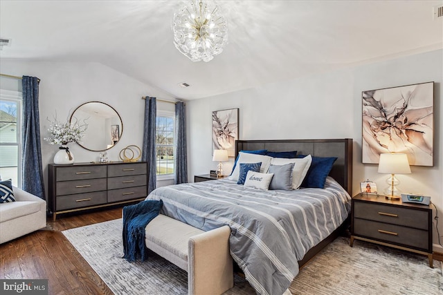 bedroom with visible vents, an inviting chandelier, lofted ceiling, and wood finished floors