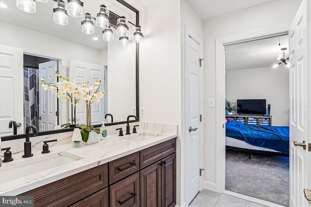 full bathroom with tile patterned flooring, connected bathroom, double vanity, and a sink