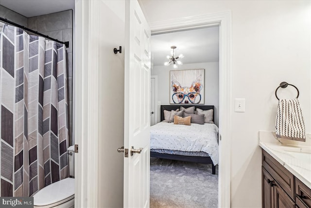 ensuite bathroom with a notable chandelier, toilet, a shower with curtain, ensuite bathroom, and vanity