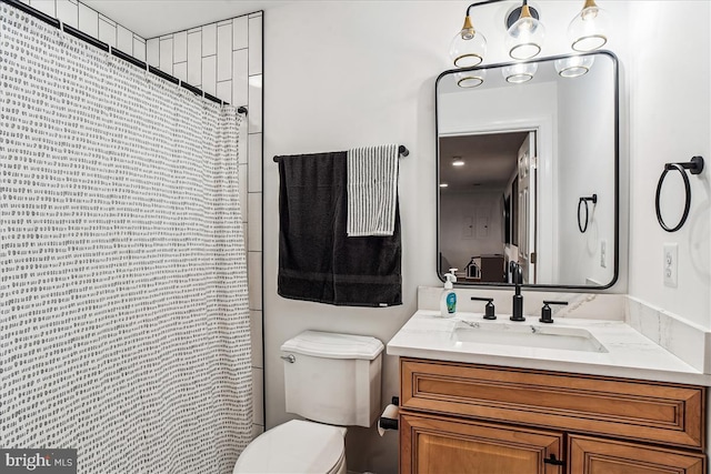 bathroom with vanity, a shower with shower curtain, and toilet