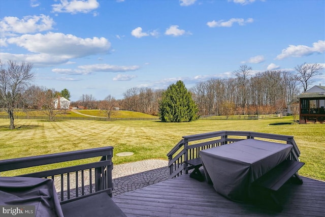 wooden terrace featuring a yard and fence