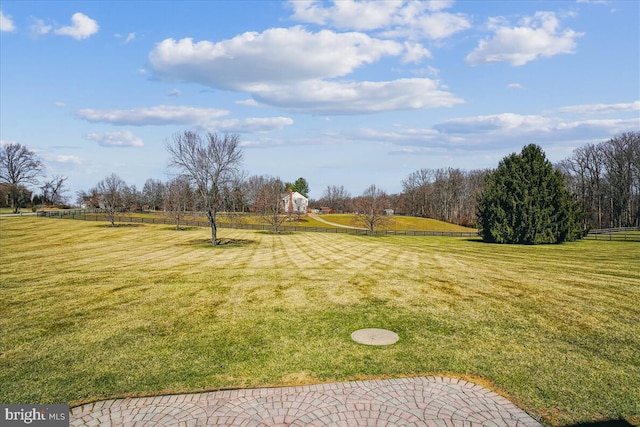 view of yard featuring a rural view and fence