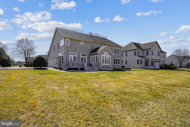 rear view of house featuring a yard and a garage