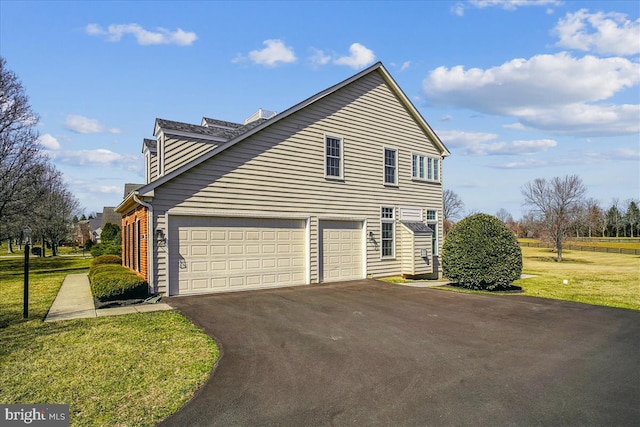 view of home's exterior featuring an attached garage, a lawn, and driveway