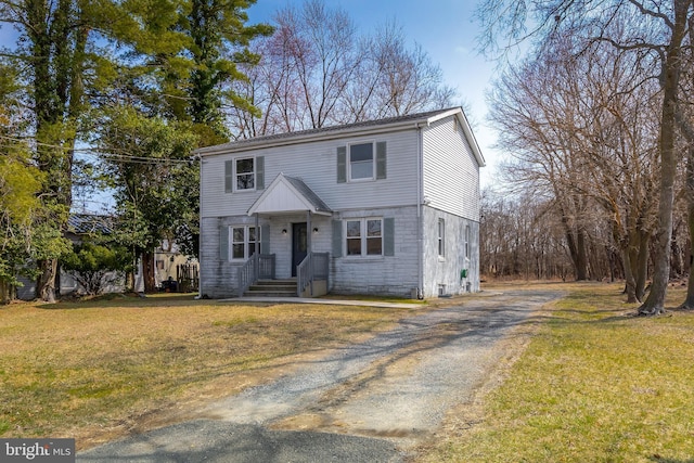 colonial inspired home featuring driveway and a front yard