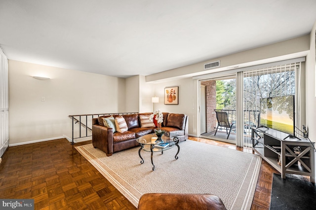 living area with baseboards and visible vents