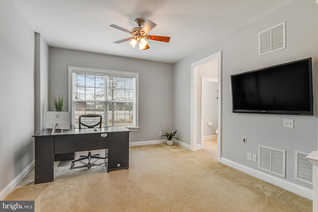 office space with visible vents, light carpet, baseboards, and ceiling fan