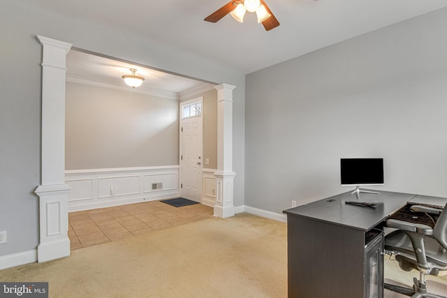 carpeted office featuring a wainscoted wall, visible vents, decorative columns, ceiling fan, and crown molding