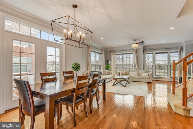 dining area featuring light wood-type flooring, stairway, plenty of natural light, and ornamental molding