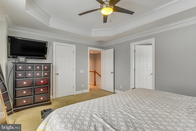 carpeted bedroom with ceiling fan, crown molding, a raised ceiling, and baseboards