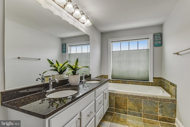 bathroom featuring a sink, a garden tub, and double vanity