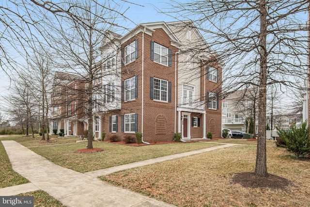 view of front of home featuring brick siding and a front yard