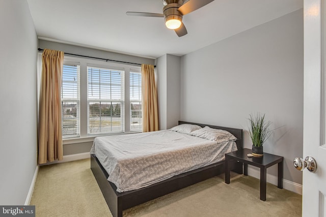 bedroom with light colored carpet, baseboards, and ceiling fan