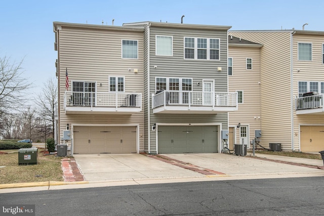 back of house with central air condition unit, driveway, and an attached garage