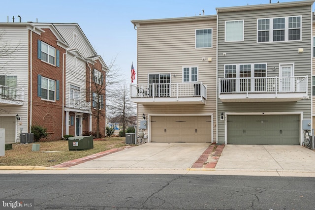 exterior space featuring central AC unit, an attached garage, and concrete driveway