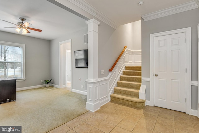 stairway with tile patterned floors, carpet flooring, a decorative wall, crown molding, and ceiling fan