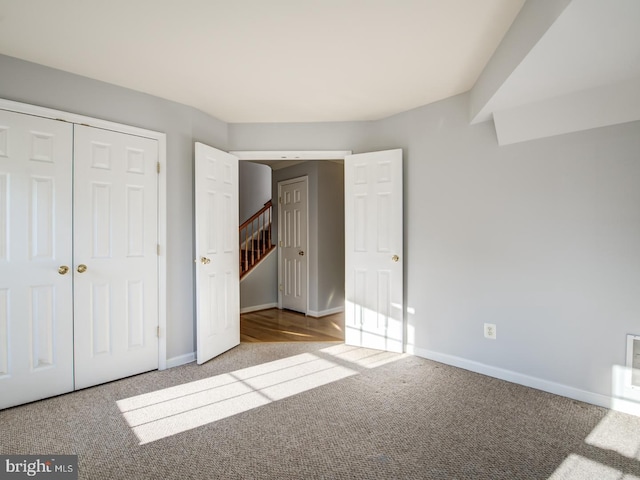 unfurnished bedroom featuring baseboards, a closet, and carpet floors