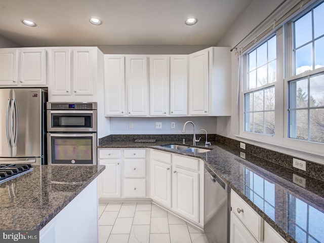 kitchen featuring a sink, appliances with stainless steel finishes, white cabinets, and recessed lighting