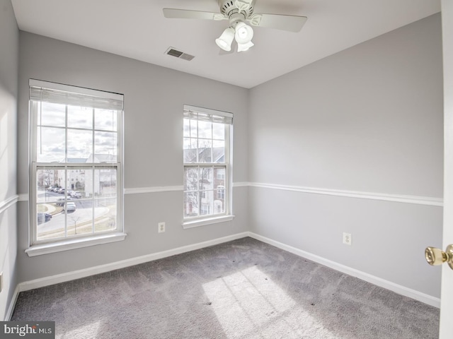 unfurnished room featuring carpet flooring, visible vents, baseboards, and ceiling fan