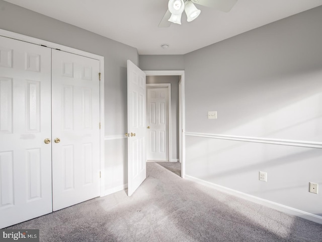 unfurnished bedroom with a closet, ceiling fan, baseboards, and carpet floors