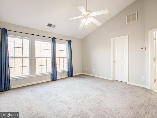 empty room featuring visible vents, carpet floors, high vaulted ceiling, and baseboards