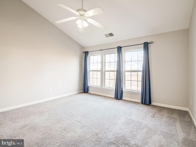 carpeted spare room featuring vaulted ceiling, baseboards, visible vents, and ceiling fan