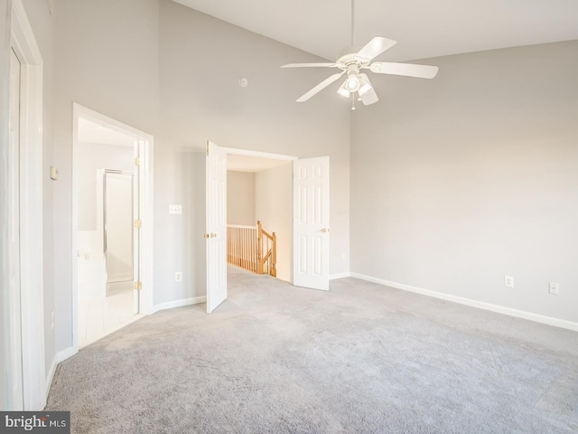 unfurnished bedroom with carpet flooring, connected bathroom, high vaulted ceiling, and baseboards