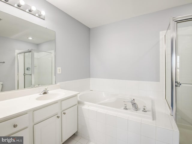 full bathroom with vanity, a garden tub, and a stall shower