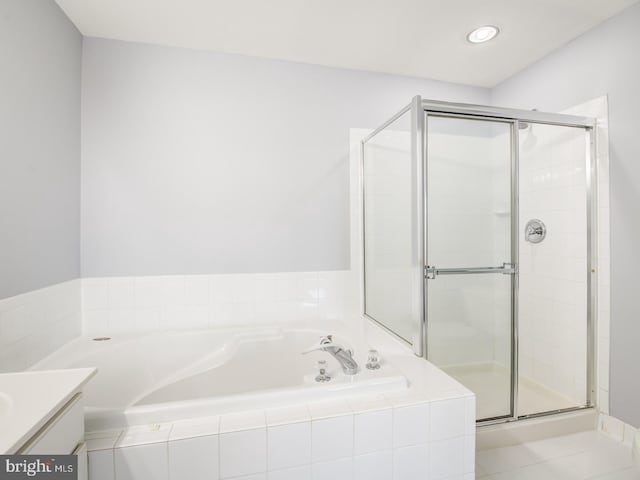 full bathroom featuring vanity, a shower stall, and a bath