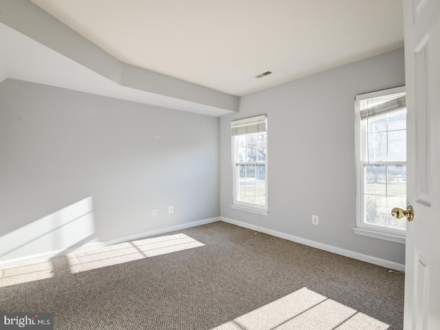 carpeted empty room with visible vents and baseboards