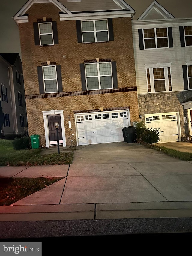 view of front facade featuring a garage, brick siding, and driveway