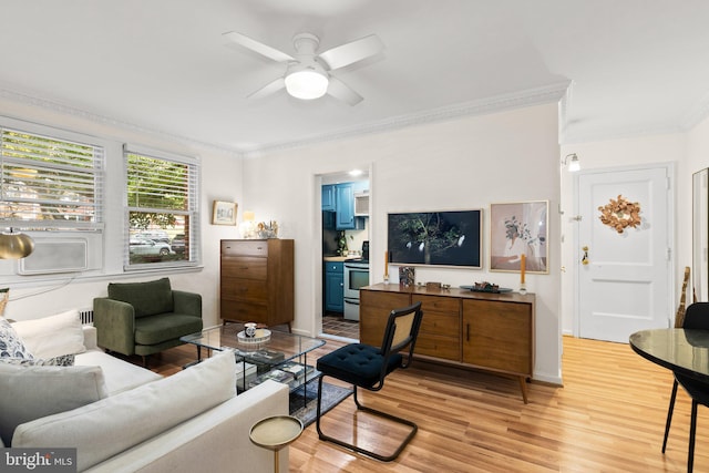 living room with baseboards, ceiling fan, crown molding, and light wood finished floors