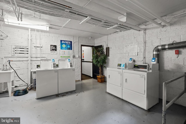 unfinished basement with washer and dryer and concrete block wall