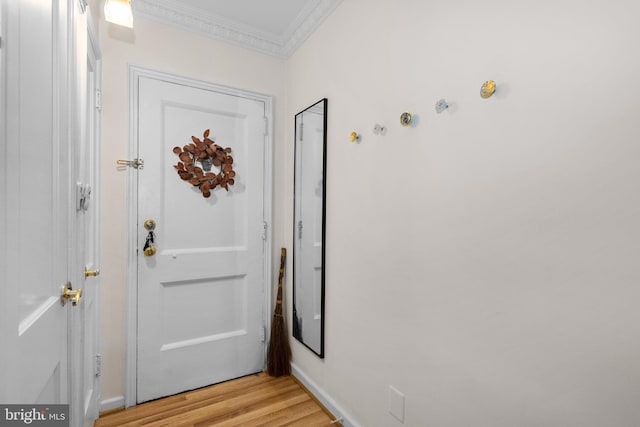 doorway to outside featuring light wood finished floors and ornamental molding