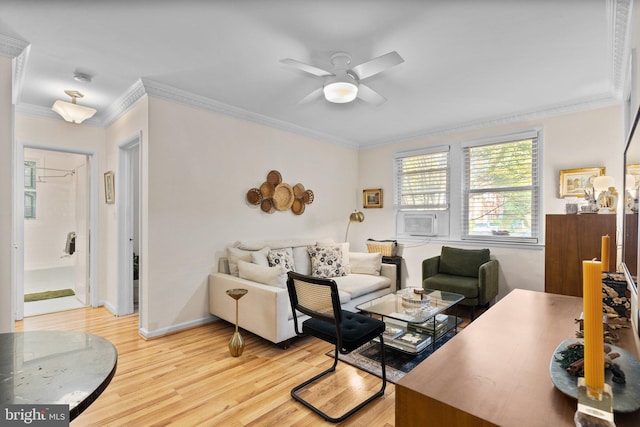 living area featuring light wood-style flooring, baseboards, a ceiling fan, and ornamental molding