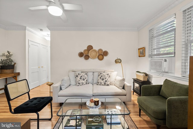 living area with light wood-type flooring, a ceiling fan, cooling unit, and crown molding